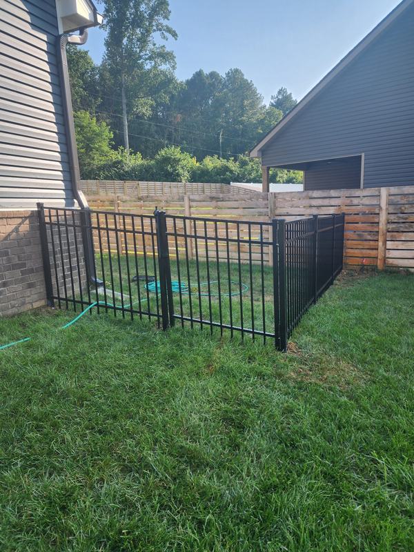 Black metal fence enclosing a side yard