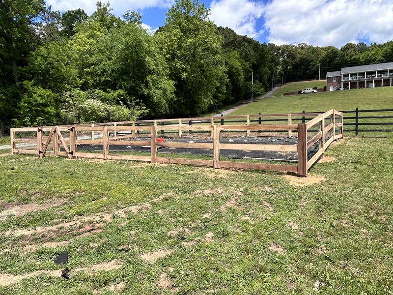 Wood and wire fence enclosing a large garden area