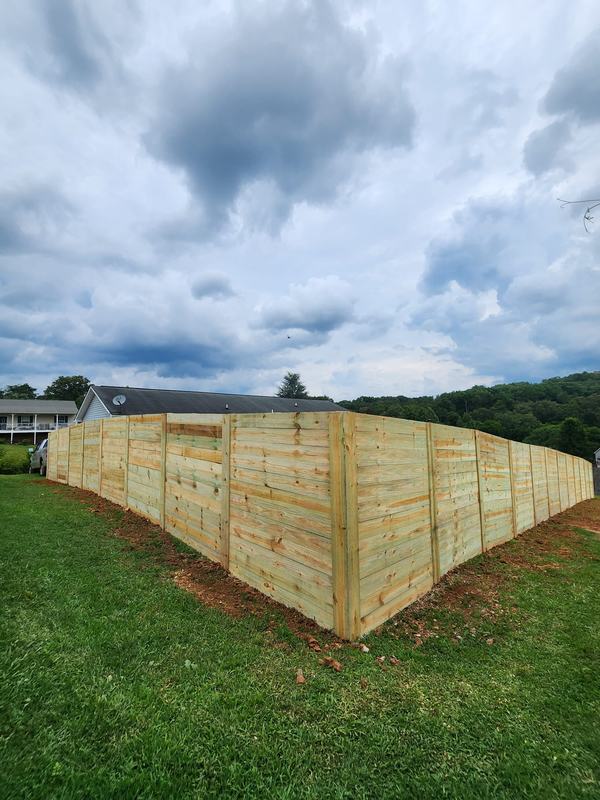 Horizontal board privacy fence wrapping the corner of a backyard
