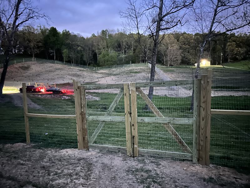 Wood post and wire pasture fence with a wide double gate
