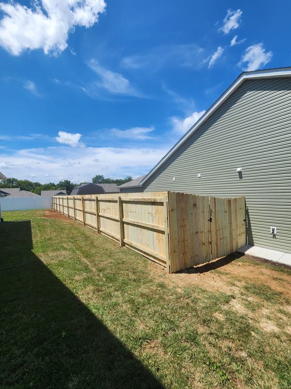 Wood privacy fence and gate along the side of a house